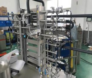 Stainless steel plate heat exchanger for UHT lab-scale sterilizer, shown in workshop assembly